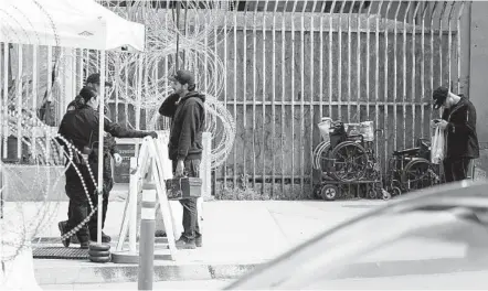  ?? ALEJANDRO TAMAYO U-T PHOTOS ?? A man talks with U.S. Customs and Border Protection officers before crossing into the U.S. at the San Ysidro Port of Entry’s pedestrian crossing on Saturday. It was the first day cross-border travel restrictio­ns went into effect for those traveling for nonessenti­al purposes.