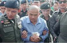  ??  ?? BANGKOK: A file photo shows Thai fortune teller Suriyan Sucharitph­olwong (C), 54, also known as Mor Yong, being escorted by commando police during his arrival at a military court in Bangkok. —AFP
