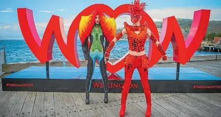  ??  ?? Two World of WearableAr­t models pose in front of the #WellyLoves­WOW sign on the Wellington waterfront.