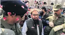  ?? PHOTO: REUTERS ?? Show of support . . . Hafiz Saeed is showered with flower petals as he walks to court before a Pakistani court ordered his release from house arrest in Lahore, Pakistan, late this week.