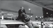  ?? AP/ITN ?? In this photo taken from video, a man with a backpack grabs a protester atop a train Thursday in London.