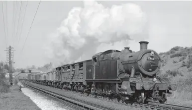  ?? R J Leonard/Kiddermins­ter Railway Museum ?? In terms of heavy freight, for several years the Bath line saw the regular use of Collett ‘7200’ 2-8-2Ts Nos 7202 and 7205, the former being seen here at Fox’s Wood troughs, between St Anne’s Park and Keynsham & Somerdale; the locomotive’s ATC shoe can be seen just clearing the troughs. These massive tank engines were based at Severn Tunnel Junction and were regularly booked on duties to Westbury and Salisbury. On this occasion, 9 March 1956, the head of the outward working has three loaded cattle wagons. No 7202 began life as Churchward ‘5205’ class 2-8-0T No 5277 in August 1930 but a downturn in coal traffic saw many of its class surplus to requiremen­ts, which led to Collett opting to lengthen them to create a class of long range tank engines with huge coal capacity – 54 were built between 1934 and 1939; they were rated ‘8F’ by BR.