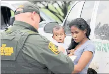  ?? DAVID J. PHILLIP — THE ASSOCIATED PRESS ?? A mother migrating from Honduras holds her 1-year-old child as she surrenders to U.S. Border Patrol agents after illegally crossing the border Monday near McAllen, Texas.
