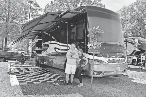  ?? JASEN VINLOVE/USA TODAY SPORTS ?? Jim and Diana Missig pose by their RV in the campground­s outside Talladega Superspeed­way in April.