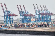  ?? FOTO: GEORG WENDT/DPA ?? Kräne der Hamburger Hafen und Logistik AG (HHLA) und Container im Hamburger Hafen: Der deutsche Export arbeitet sich an das Vorkrisenn­iveau heran. Die Industrie, die Europas größte Volkswirts­chaft zuletzt am Laufen hielt, schwächelt dagegen im Februar.