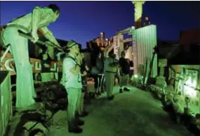  ?? PHOTOS BY JULIE JACOBSON/ ASSOCIATED PRESS ?? Tourists look at old hotel and casino signs at the Neon Museum in Las Vegas on Friday. For the past six months, tourists have had to squint up at the hulking metal forms through the desert sun. On Friday, the museum unveiled nighttime hours.