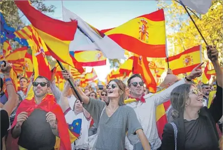  ?? Jeff J Mitchell Getty Images ?? IN BARCELONA, supporters of Spanish unity demonstrat­e two days after the Catalan regional parliament voted to split from Spain. The mostly peaceful rally came as an opinion poll published Sunday showed Catalonia to be nearly evenly divided on...