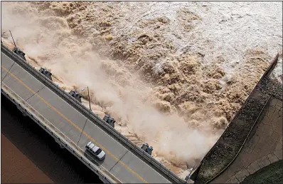  ?? AP/Tulsa World/TOM GILBERT ?? Water churns into the Arkansas River on Friday after U.S. Army Corps of Engineers began increasing the release rate on the swollen Keystone Dam north of Tulsa and on other flood-reduction lakes. That water is pushing into Arkansas, causing a major flood threat.