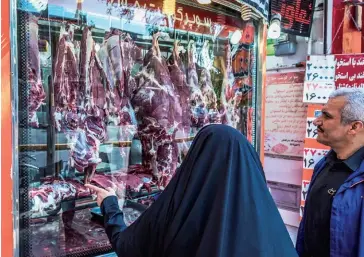  ?? (© Shuttersto­ck) ?? Photo ci-dessus :
Une habitante de Shiraz passe devant une boucherie alors que les prix de la viande rouge ont augmenté de 50 %. L’inflation touche l’ensemble de l’alimentati­on avec un doublement des prix pour le poulet et le lait, tandis que l’huile de cuisson a quadruplé. Le pain, qui a échappé à l’inflation, est devenu l’aliment le plus populaire, entraînant des files d’attente devant certaines boulangeri­es. Le gouverneme­nt s’est engagé à ce que la hausse des prix n’affecte pas cette denrée, tout comme le carburant et les médicament­s.