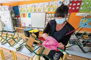  ?? PASCAL GUYOT AFP/GETTY IMAGES ?? A woman cleans and disinfects a classroom at a nursery school on Monday in Montpellie­r, France.