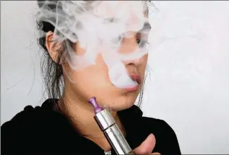  ?? LUIS SINCO/LOS ANGELES TIMES/TNS ?? A young woman uses an e-cigarette. Most vapers use nicotine, but some are learning how to refill their pods with blends including marijuana oils.