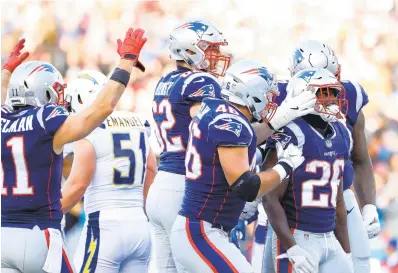  ?? ELSA/GETTY IMAGES ?? Sony Michel celebrates with his fellow Patriots after scoring a touchdown in the second quarter. He ran for 129 yards and had three touchdowns as the Patriots beat the Los Angeles Chargers 41-28 in the divisional playoffs.