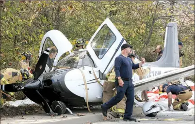  ?? NWA Democrat- Gazette/ DAVID GOTTSCHALK ?? Emergency responders secure the scene of a small plane crash Tuesday on Martin Luther King Boulevard in Fayettevil­le. Former WalMart CEO Bill Simon and two other men were on the plane, which deployed a parachute after developing engine problems. All...