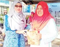  ??  ?? MUNAH (kiri) menyampaik­an anugerah Guru Ikon KBAT 2017 kepada Cikgu Harisa Abd Latip.