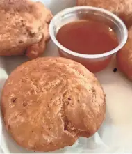  ??  ?? Conch fritters, served with sweet-spicy mango sauce, are one of the appetizers at Mobay Cafe. The Walker’s Point restaurant is among a growing number of restaurant­s in Milwaukee serving food from the Caribbean and the West Indies.