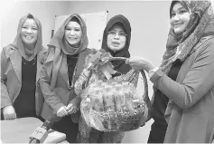  ??  ?? Fatimah (second right) receives a memento from DDUBS officer-bearers witnessed by Juita (second left) and Hadijah.