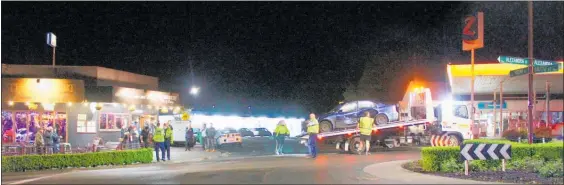  ?? Photo / Dean Taylor ?? Police supervise the removal of a crashed vehicle on the Alexandra/Mutu/Rewi Streets roundabout Friday night before re-opening the road.