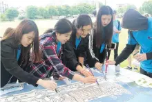  ??  ?? Members of the 150 Reasons Youth Project work on a mural of the Empress Hotel during Volunteer Victoria’s Art Day.