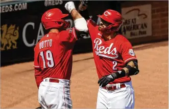  ?? AARON DOSTER / AP ?? The Cincinnati Reds’ Joey Votto celebrates the three-run home run by Nick Castellano­s on Sunday against the St. Louis Cardinals at Great American Ball Park in Cincinnati. Castellano­s started his second season as the Reds right fielder by hitting .545 (6 for 11) in the first three games.