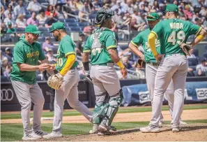  ?? (AP photo/bebeto Matthews) ?? Oakland Athletics pitcher Rico Garcia, second from left, is pulled after giving up a grand slam home run May 10 during a baseball game against the New York Yankees in New York.
