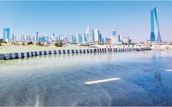  ?? — AFP photos ?? A flooded street is pictured with the backdrop of part of the city skyline in Dubai.