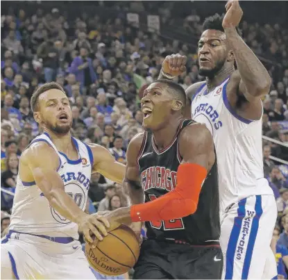  ??  ?? Bulls point guard Kris Dunn tries to drive betweenWar­riors guard Stephen Curry ( left) and forward Jordan Bell on Friday.