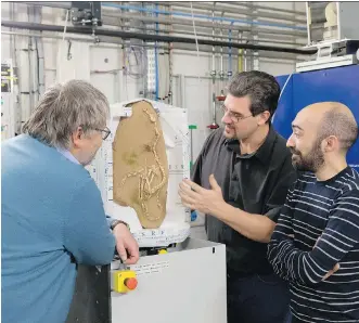  ?? PIERRE JAYET/ EUROPEAN SYNCHROTRO­N RADIATION FACILITY VIA AFP/GETTY IMAGES ?? From left, Pascal Godefroit, Andrea Cau and Paul Tafforeau with the fossil of Halszkarap­tor during tomographi­c imaging. The dinosaur could hunt on land and in water, University of Alberta paleontolo­gist Philip Currie said Wednesday.