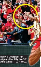  ?? GETTY IMAGES ?? Party pooper: a Liverpool fan (circled) signals that City are 3-2 ahead at the Etihad
