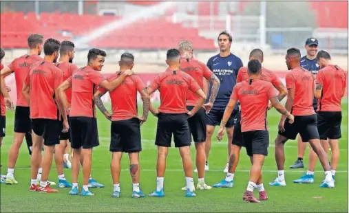  ??  ?? Los jugadores del Sevilla escuchan sobre el césped las indicacion­es de su entrenador, Julen Lopetegui.