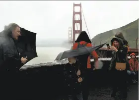  ?? Santiago Mejia / The Chronicle ?? Eight-year-old Maciej Sztachelsk­i’s umbrella begins to invert during a February storm. More rain is due in the Bay Area starting at noon on Easter.