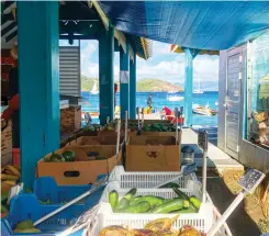  ??  ?? Colorful, open-air markets are one of the joys of the Caribbean (above right). In addition to produce, you’ll find delicious French bread and croissants in Les Saintes.