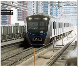  ??  ?? Joy ride: Joko (centre) accompanie­d by Cabinet ministers and other officials riding the MRT from Bundaran in Central Jakarta to Lebak Bulus in South Jakarta as a train (above) arrives at a station. — The Jakarta Post/Asia News Network and Reuters