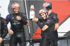  ?? Mark Lloyd / AFP / Getty Images ?? Emirates Team New Zealand trimmer Blair Tuke celebrates with teammates after winning the series against Artemis Racing.