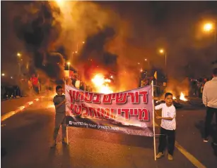  ?? (Amir Cohen/Reuters) ?? ‘WE WANT immediate and absolute security’: Residents of the South protest the ceasefire in Sderot last night.