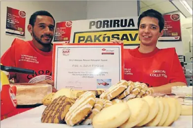  ??  ?? Chopper deal: Westpac customer service representa­tives George Tilsley and Chris Marshall with some of the fast-selling biscuits donated by Pak ’n Save for the Chopper Appeal.