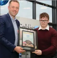  ??  ?? Student Oisin Moloney presenting Thomas Byrne TD with a token