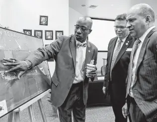  ?? Photos by Marvin Pfeiffer / Staff photograph­er ?? Cibolo City Councilmen Doug Garrett, from left, and Brian Byrd look at a plat of the plant site with attorney Beto Cardenas of Vinson Elkins.