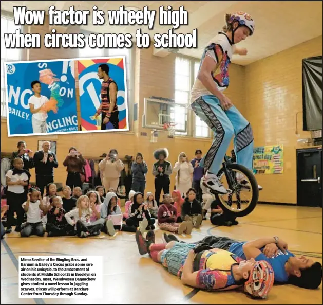  ?? ?? Mimo Seedler of the Ringling Bros. and Barnum & Bailey’s Circus grabs some rare air on his unicycle, to the amazement of students at Middle School 35 in Brooklyn on Wednesday. Inset, Wendwesen Dagnachew gives student a novel lesson in juggling scarves. Circus will perform at Barclays Center from Thursday through Sunday.