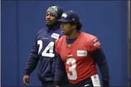  ??  ?? ELAINE THOMPSON — THE ASSOCIATED PRESS Seattle Seahawks running back Marshawn Lynch, left, looks across at quarterbac­k Russell Wilson during warmups at the team’s practice facility in Renton, Wash., on Tuesday.