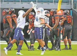  ?? AL DIAZ/ASSOCIATED PRESS ?? North Carolina linebacker­s Tomon Fox, left, and Jeremiah Gemmel celebrate a stop against Miami on Saturday in Miami Gardens, Fla. The Hurricanes were routed 62-26.