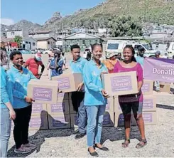  ?? ?? IMIZAMO Yethu fire victims receive a kitchen starter kit from the internatio­nal humanitari­an organisati­on, WeLoveU Foundation.