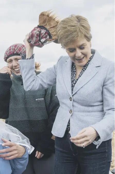  ?? ?? ← Nicola Sturgeon wears a wig and hat as she poses with members of a hen party on the campaign trail at Portobello beach in Edinburgh