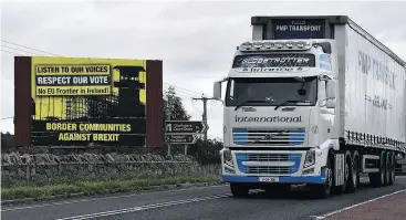  ?? CHARLES MCQUILLAN / GETTY IMAGES ?? A lorry crosses the border past a Border Communitie­s Against Brexit billboard in Newry, Northern Ireland. Talks on the Irish border are thought to be at a crucial stage.