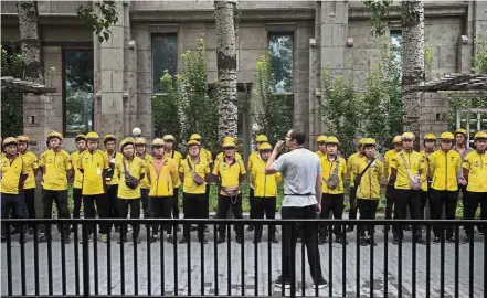  ?? — AFP ?? Public listing: A file picture showing Meituan food delivery workers attending a morning briefing in Beijing. Chinese online services giant Meituan-Dianping is seeking to raise more than US$4bil from an IPO in Hong Kong.