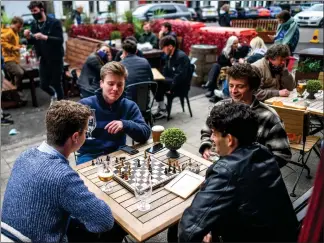  ??  ?? A group of men play chess while drinking outside in St Andrews as lockdown rules were lifted