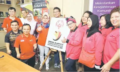  ?? — Gambar Muhammad Rais Sanusi ?? LANCAR: Fatimah melancarka­n logo Sukan Olimpik Khas Negeri Sarawak Cabang Kuching 2018 disaksikan Dayang Mariani (tiga kanan) serta yang lain.