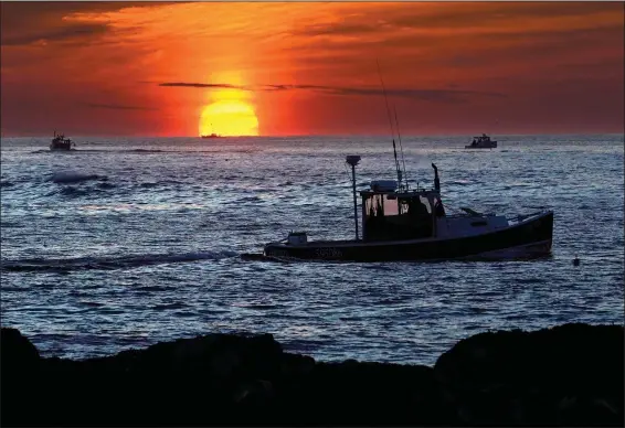  ?? (File Photo/AP/Robert F. Bukaty) ?? Lobster fishermen work at sunrise Sept. 8 off Kennebunkp­ort, Maine. The waters off New England logged the second-warmest year in their recorded history in 2022, according to researcher­s.