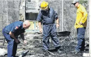  ?? PHOTO: GUY WILLIAMS ?? Police and firefighte­rs inspect the scene of the Mt Aurum homestead fire at Skippers, near Queenstown, in January.