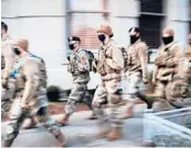  ?? SPENCER PLATT/GETTY ?? Members of the National Guard patrol the streets on the eve of Inaugurati­on Day in Washington.