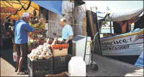  ?? ?? A man buys fruits at the Punda floating market on the waterfront of old town Willemstad, Curacao.